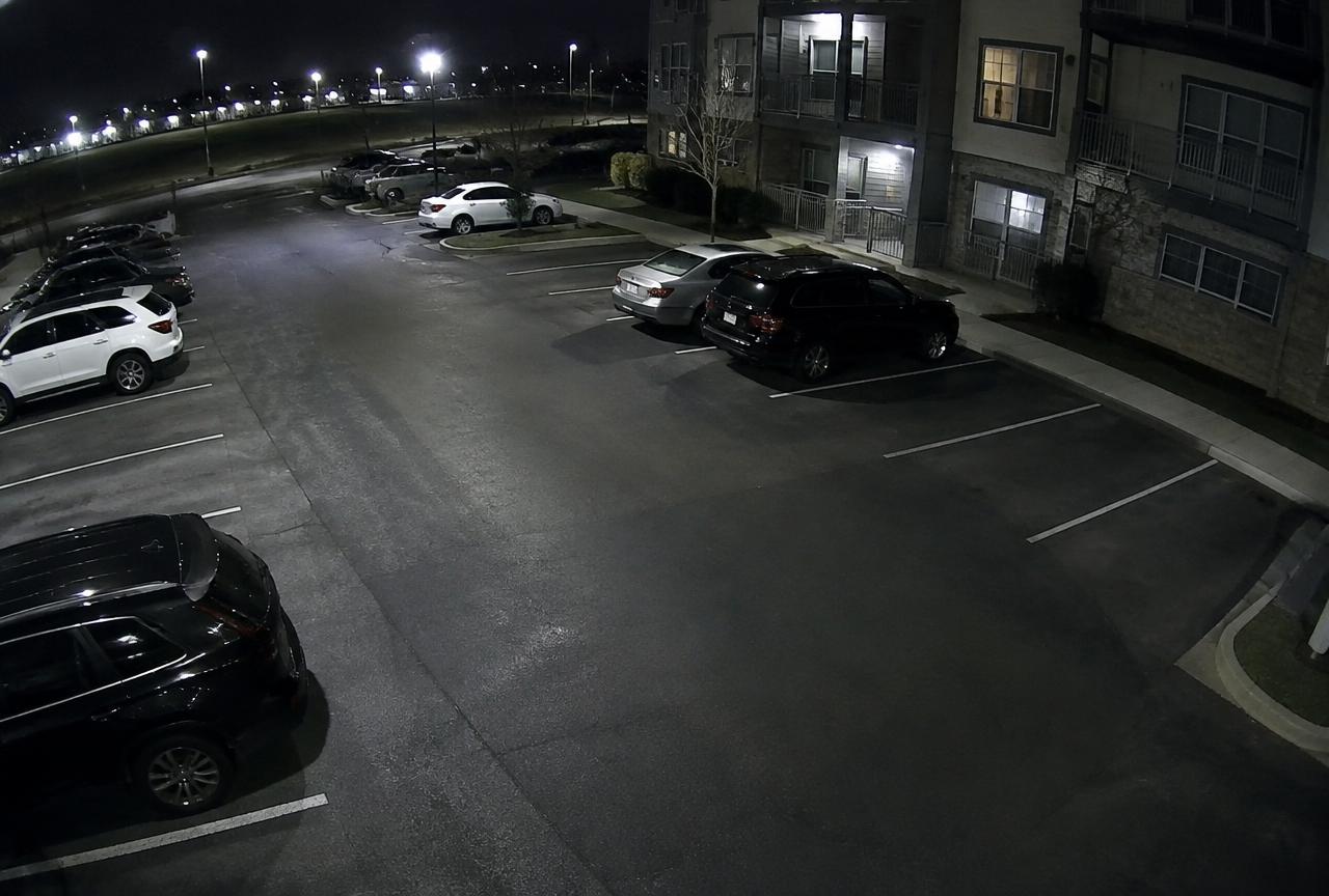 Full-color nighttime surveillance image of a parking area captured by an AI-enabled camera